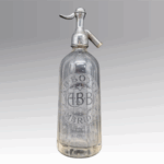 Heavy clear glass bottle with fluted sides and metal syphone top. Circular label etched into one side of the bottle - "A.B. BOYCE CAMBRIDGE" encircling the initials "A.B.B."